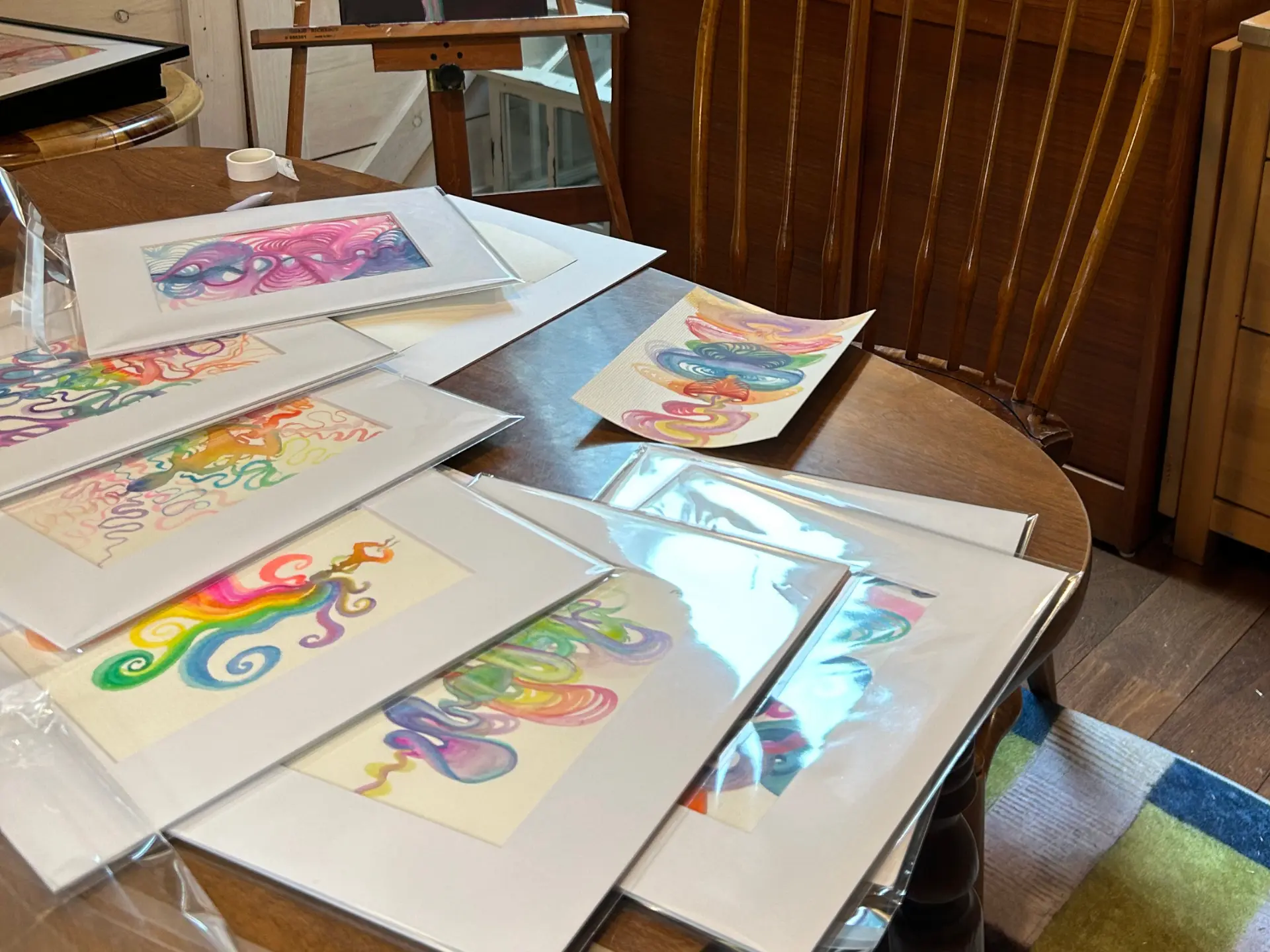 Colorful original watercolors, matted and laid out in Alli’s studio